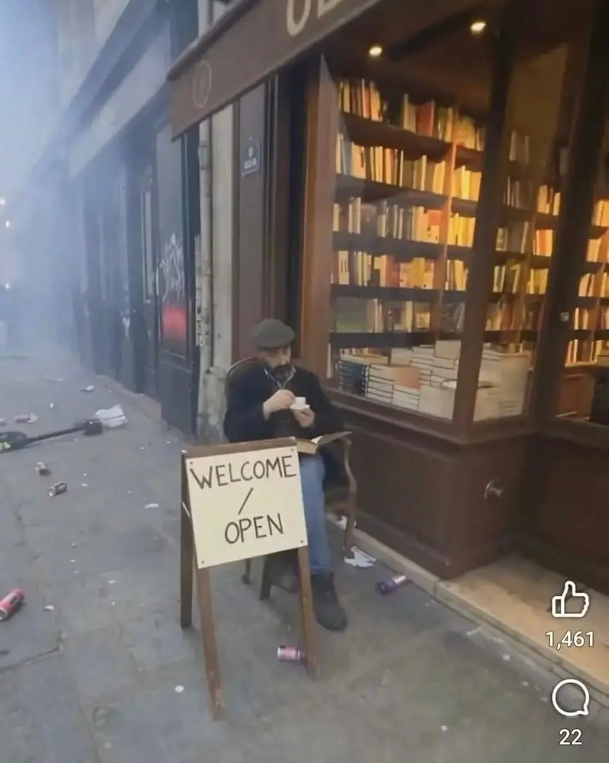 🇫🇷 A French book store owner sits outside his un.jpg